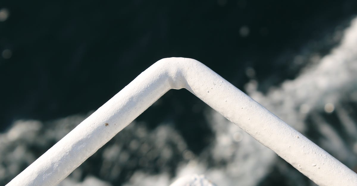 A close-up view of white metal railings with water in the background, showcasing industrial design.