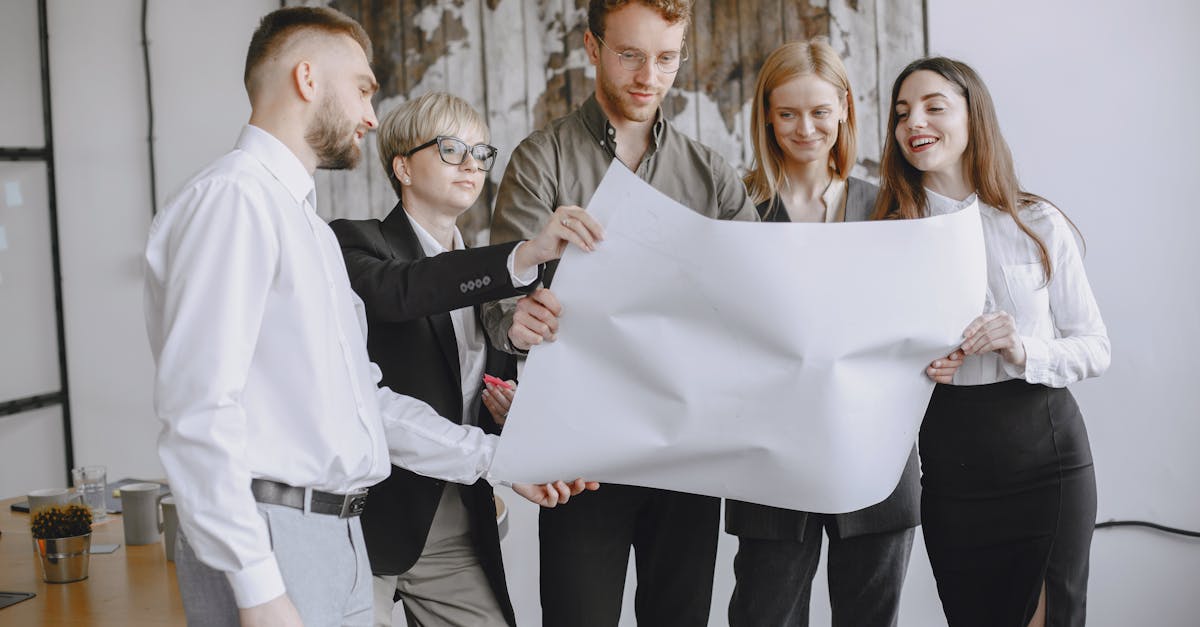Group of professionals in an office setting analyzing project plans together.